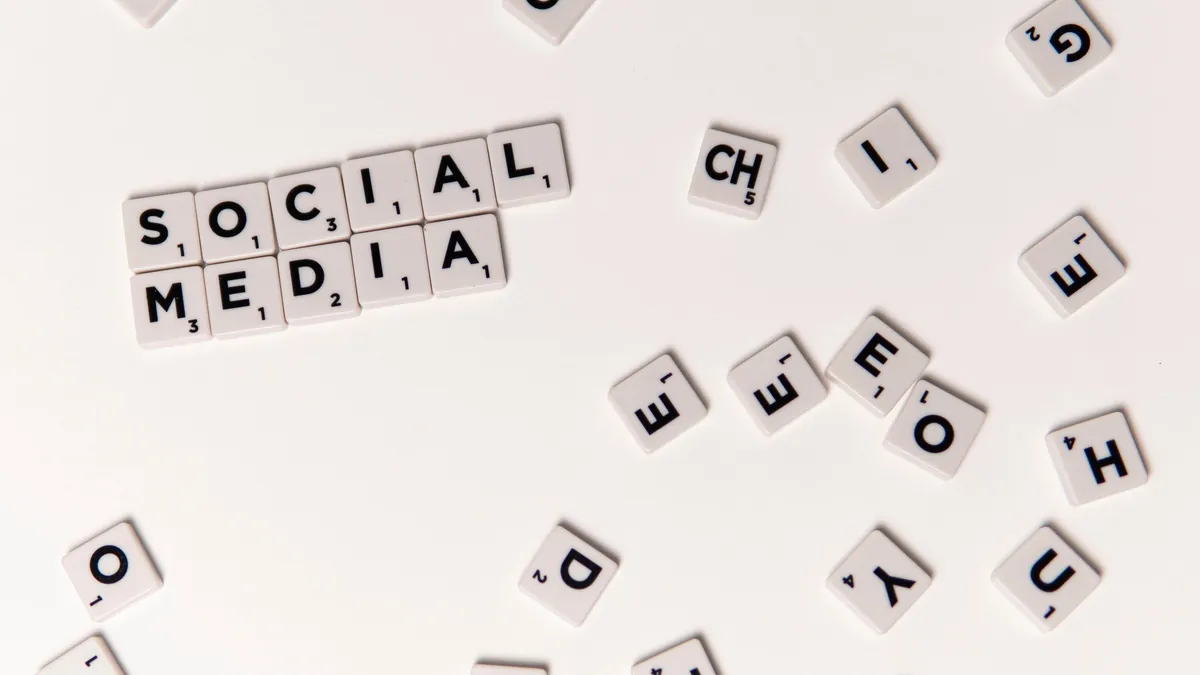 Meta Ads automatisieren: Scrabble-Steine bilden das Wort Social Media, umgeben von verstreuten Buchstaben
