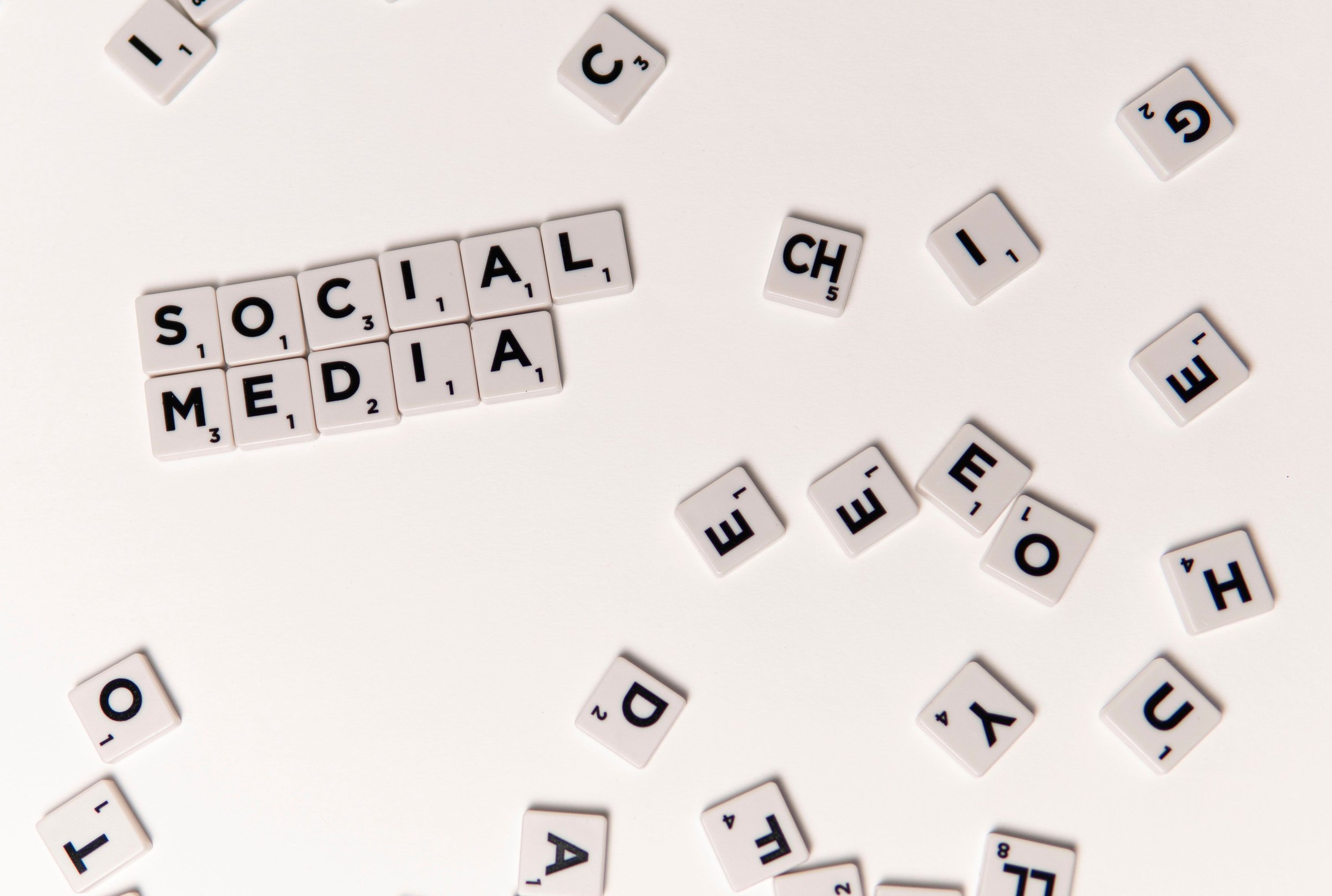 Meta Ads automatisieren: Scrabble-Steine bilden das Wort Social Media, umgeben von verstreuten Buchstaben